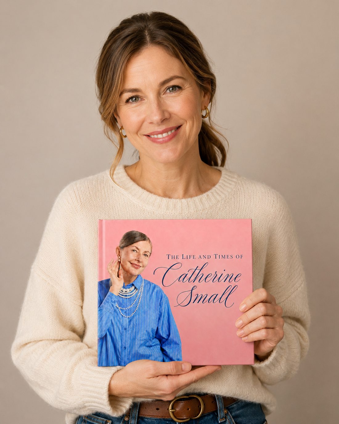 A daughter holding a finished photo-rich legacy book about Catherine Small